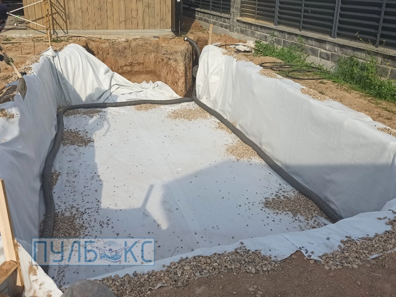 Выстилание котлована геотекстилем и укладка дренажной трубы